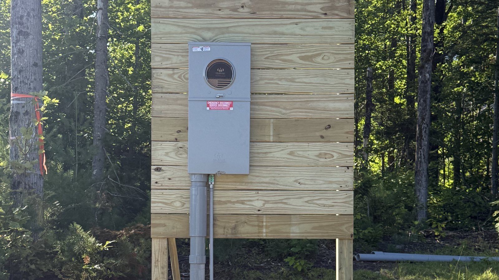 New Milbank meter socket and emergency service disconnect on a pressure-treated pole board